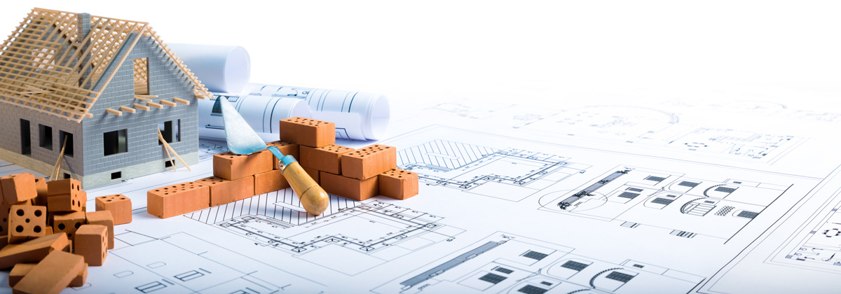 Building a house with bricks and home construction loan plans on a wooden surface.