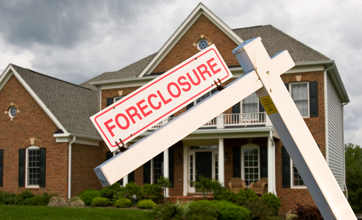 Foreclosure sign in front of a modern house